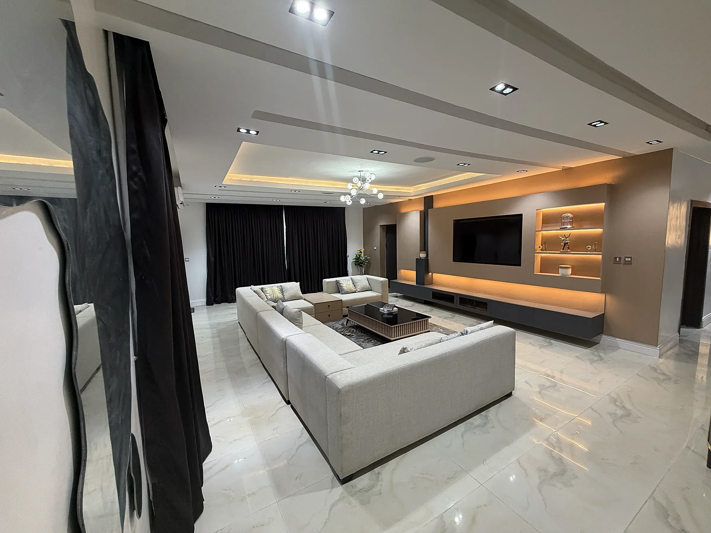 Living room media wall and large sectional seating at Canary Penthouse